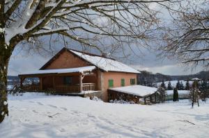 domaine de la louvière في Le Clerjus: منزل مغطى بالثلج في ساحة ثلجية