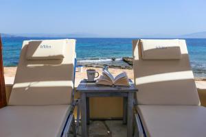 two chairs and a table with a book on the beach at Irides in Souvala