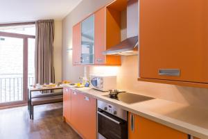 a kitchen with orange cabinets and a sink at Pierre & Vacances Andorra Bordes d’Envalira in Bordes d´Envalira 