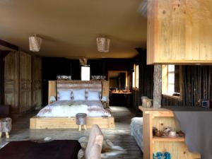 a bedroom with a bed in a wooden room at Comptoir Saint-Hilaire in Saint-Hilaire-de-Brethmas