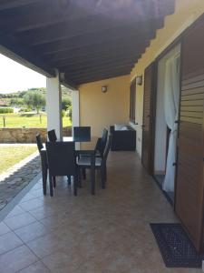 a patio with a table and chairs and a couch at Abba Urci in Tertenìa