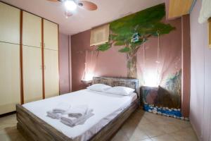 a bedroom with a bed with a painting on the wall at Dream Catcher Artemis in Artemida