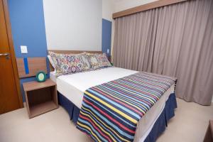 - une chambre avec un lit et une couverture rayée colorée dans l'établissement Alta Vista Thermas Resort, à Caldas Novas 33 autres photos