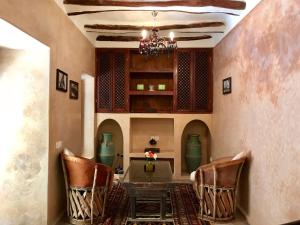 une salle à manger avec une table, des chaises et un lustre dans l'établissement Riad AKL, à Marrakech