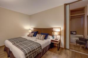 a hotel room with a large bed and a chair at Pierre & Vacances Andorra Bordes d’Envalira in Bordes d´Envalira 