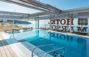 een groot zwembad met uitzicht op het water bij Hotel Marsol in Lloret de Mar