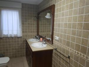 ポブラ・ド・カラミニャルにあるPrecioso Apartamento, cerca de la playaのバスルーム(洗面台2台、鏡、トイレ付)