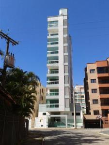 un edificio blanco alto con muchas ventanas en Apartamento 101, en Itapema