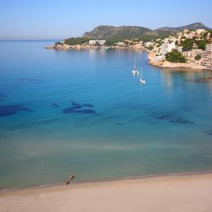 eine Luftansicht auf einen Strand mit Booten im Wasser in der Unterkunft Valentin Somni Hotel & Suites in Paguera