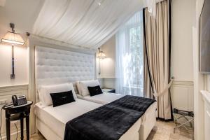 Un ou plusieurs lits dans un hébergement de l'établissement Hotel dei Quiriti Suite