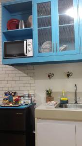 a kitchen with blue cabinets and a sink at The Treehouse B @ Trees Residences in Manila