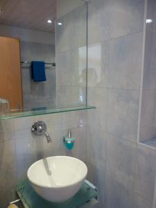 ein Bad mit einem Waschbecken und einer Glasdusche in der Unterkunft Haus Rubin in Saas-Almagell