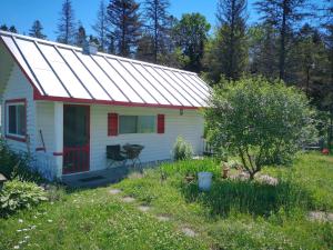 una pequeña casa blanca con una puerta roja en Chalet Le Semeur en Saint Elie