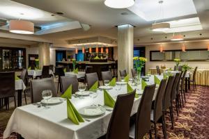 a dining room with tables and chairs with green napkins at Hotel-Restauracja Platan in Chrzanów