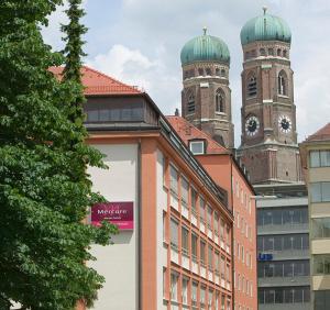 a tall building with a clock on top at Mercure Hotel München Altstadt in Munich