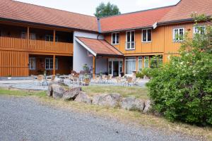 a building with tables and chairs in front of it at Søstrene Storaas hotell in Bolkesjø