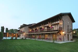 a large brick building with a lawn in front of it at Agriturismo Malabaila in Canale
