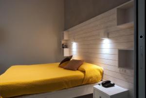 a bedroom with a bed and a lamp on the wall at La Sciabica in Agropoli