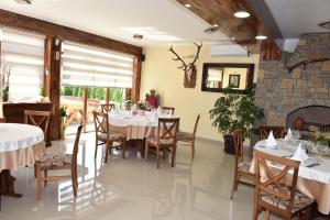 a dining room with tables and chairs and a fireplace at Hotel "VIR" in Velika Plana