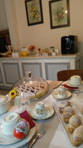 a table with a cake and some pastries on it at La Ida Bed and Breakfast in Villareggia