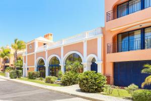 um edifício laranja com portas de garagem azuis numa rua em Golf F5 by Garvetur em Vilamoura