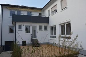 una casa blanca con techo negro en BodenSEE Apartment Allensbach FEWO 2, en Allensbach