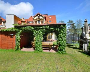 a gazebo with a bench in front of a house at Dafne 2 in Niechorze