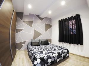 um quarto com uma cama preta e branca num quarto em Apartamentos Ainara em Santa Cruz de Tenerife