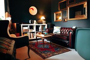 a living room with a leather couch and a table at el gran sueño Boutique Hotel & Apartamentos - Adults Only in Pintueles