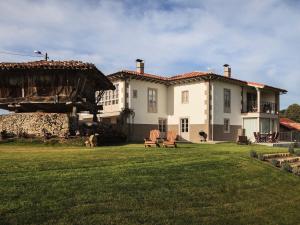 a large house with two chairs in a yard at el gran sueño Boutique Hotel & Apartamentos - Adults Only in Pintueles