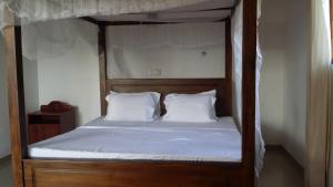 a canopy bed with white sheets and white pillows at Ocean on house in Unawatuna +15 photos