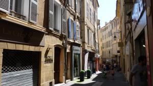een steegje met mensen die door een straat lopen met gebouwen bij Appartement de Charme in Aix-en-Provence