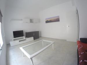 ラスパルマス・デ・グランカナリアにあるPiso Centrico y Nuevoの白いリビングルーム(テーブル、テレビ付)