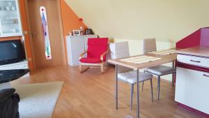 - un salon avec une table, des chaises et une télévision dans l'établissement Ferienhaus Hildegard, à Muhr amSee