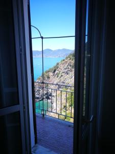 una porta aperta su un balcone con vista sull'oceano di Casa Belsito a Corniglia