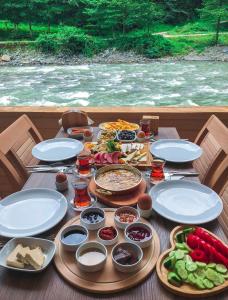 uma mesa com pratos de alimentos e legumes em Kiyi Bungalov em Çamlıhemşin