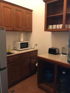 a kitchen with wooden cabinets and a microwave at Easy Inn Hotel in Belize City