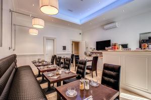 a restaurant with tables and chairs and a bar at Hotel Giuggioli in Rome