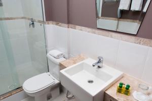 a bathroom with a sink and a toilet and a shower at Favorita Golden Hotel e Eventos in São José