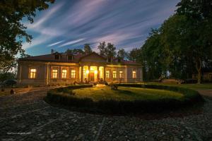 uma casa grande com as luzes acesas à noite em Dwór Bieganów em Bieganów