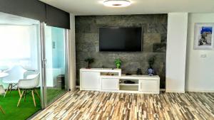 ein Wohnzimmer mit einem TV an der Wand in der Unterkunft Estupendo Preciosas Vistas in Alicante