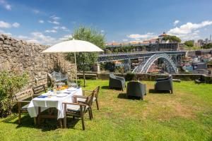 un tavolo e sedie con ombrellone in erba di Manor House Porto a Porto