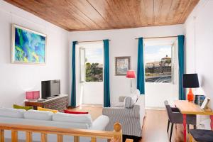 un soggiorno con mobili bianchi e tende blu di Manor House Porto a Porto