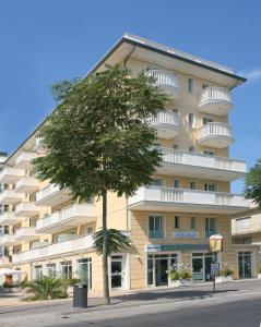 a large building with a tree in front of it at Residence T2 in Rimini