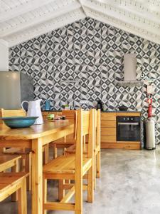 a kitchen with wooden tables and chairs and a wall at Casa do Sal in Madalena