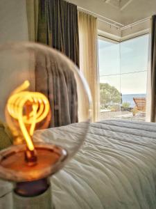 Una vela en un tazón en una cama con ventana en Casa do Sal en Madalena