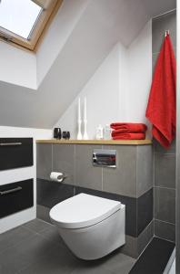 a bathroom with a white toilet and a red towel at Apartament Senatorski in Kazimierz Dolny