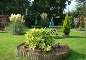a garden with a picnic table and a bench and flowers at Bird In Hand in Henlow