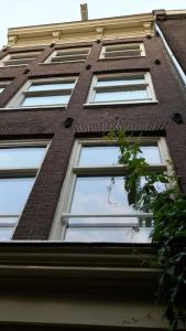 um edifício alto de tijolos vermelhos com janelas brancas em Bed & Breakfast WestViolet em Amsterdã