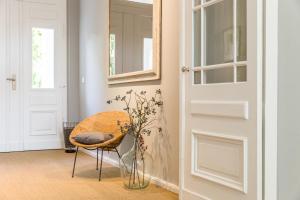 Cette chambre dispose d'une porte et d'une chaise avec un vase. dans l'établissement OSTKÜSTE - Nadler Hof Design Apartments, à Ahlbeck